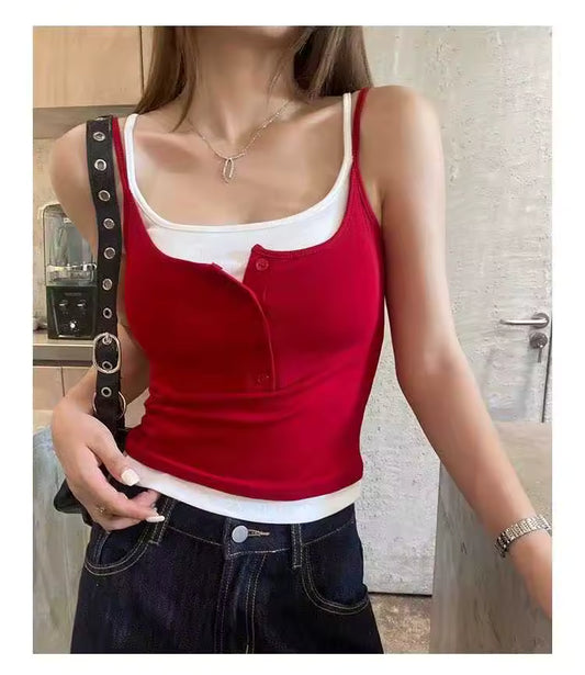 Person wearing a red tank top over a white shirt in an indoor setting