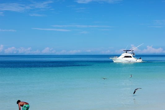 white boat on sea under blue sky during daytime