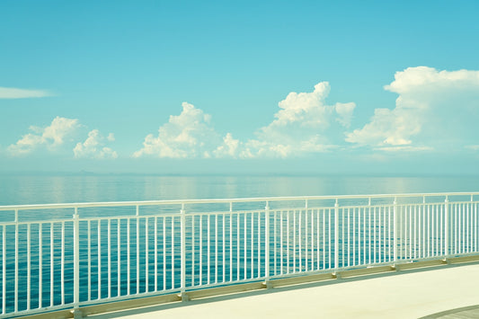A peaceful scene of ocean, sky, and railing.