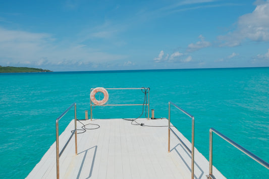 White deck with life preserver overlooks turquoise ocean