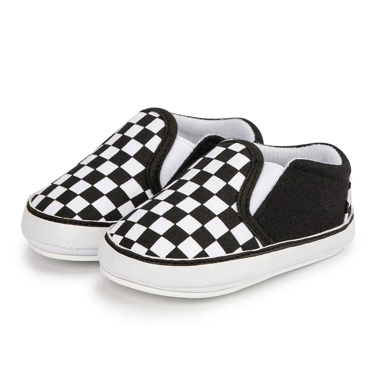 Pair of kids’ slip-on sneakers with black-and-white checkerboard pattern on a white background.