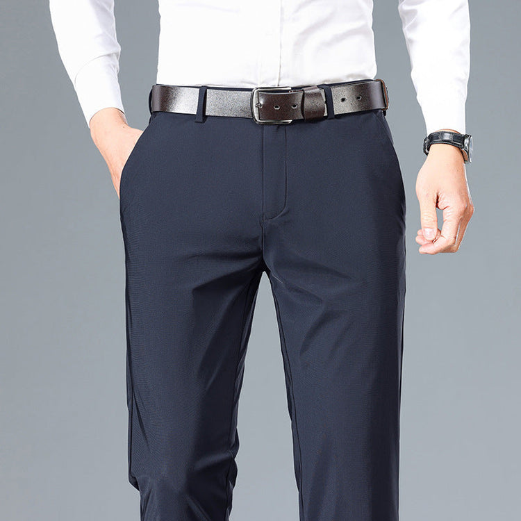 Man wearing tailored navy dress pants with a white shirt and black belt—versatile men’s bottoms for travel and evening wear.