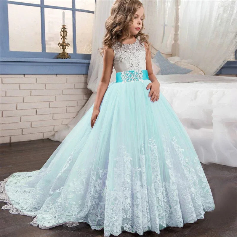 Little girl in a white lace formal dress, smiling and posing indoors—kids’ cruise-ready formal wear.