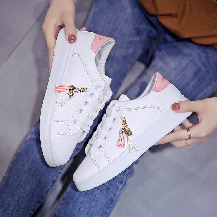 White teen sneakers with pink accents and tassel charms – teen shoes for cruise fashion, vacation wear, and everyday style.