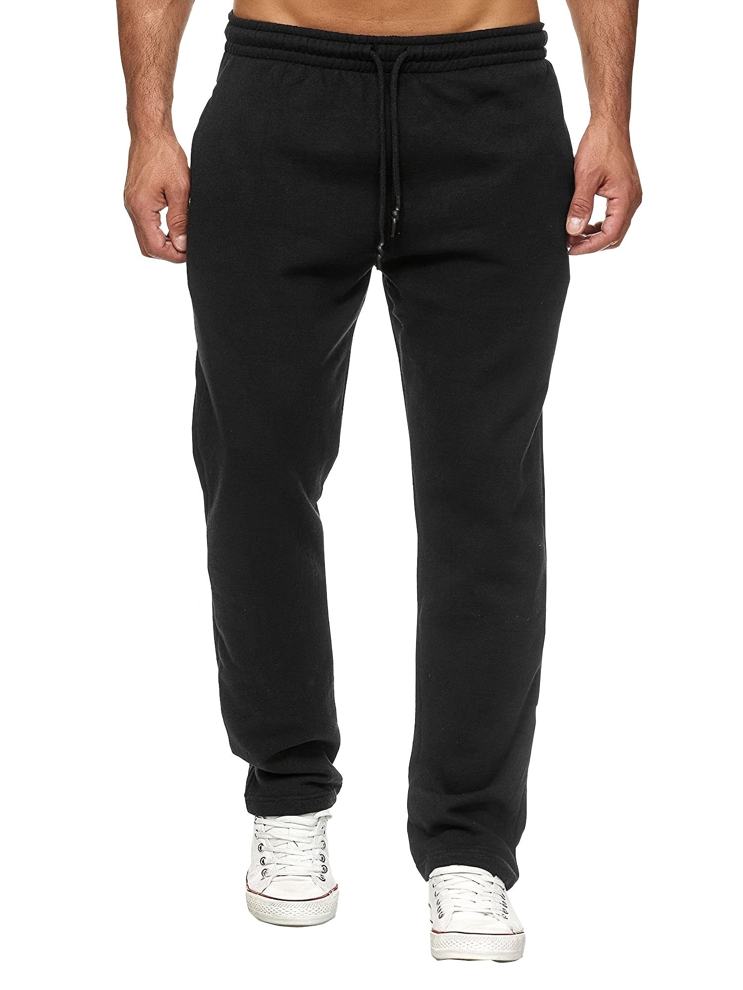 Black sweatpants worn by a person on a white background