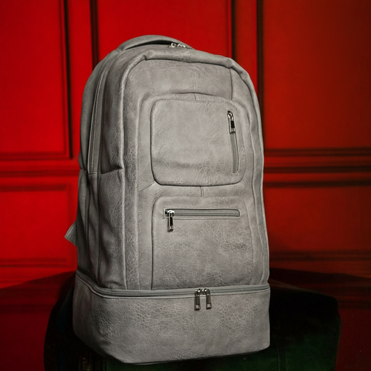 Gray backpack on a black surface with a red background