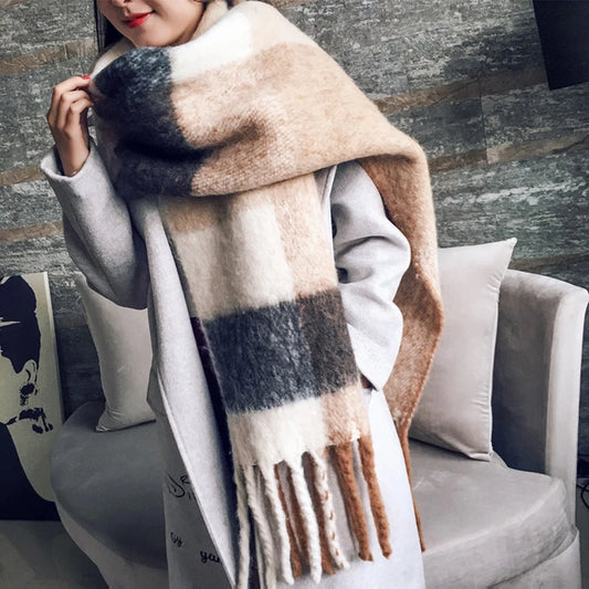 Person wearing a large plaid scarf in a cozy indoor setting
