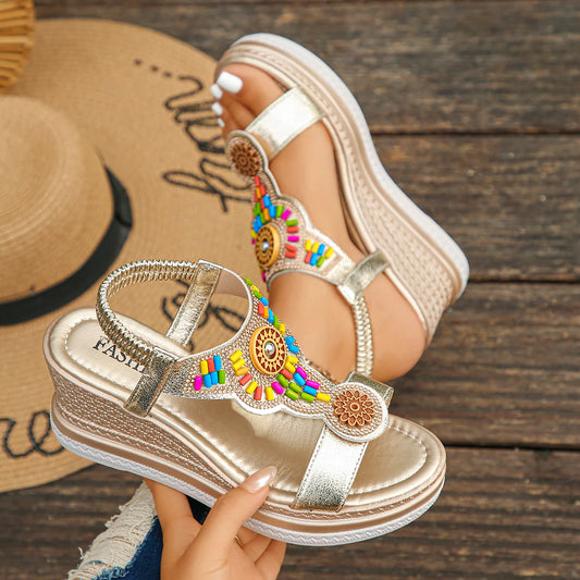 Decorative sandal with colorful beads on a wooden surface