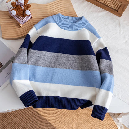 Striped sweater with blue, white, and gray colors on a textured surface.