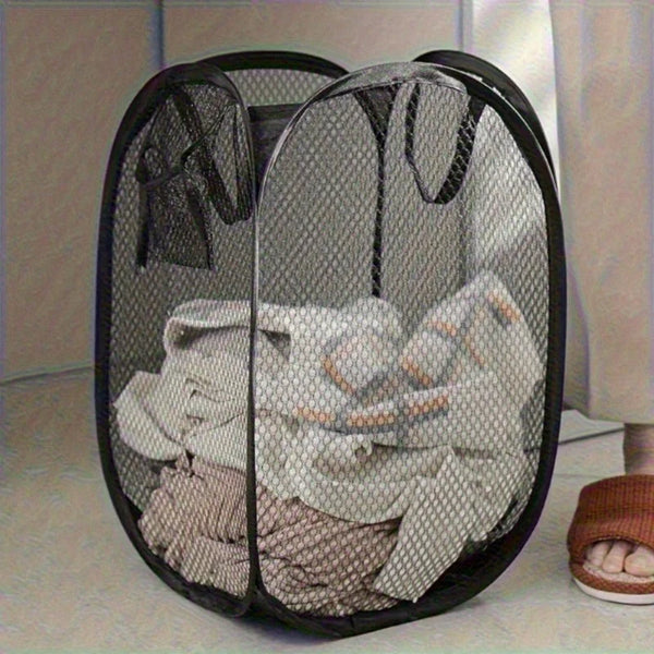 Mesh laundry basket with clothes inside on a light-colored floor.