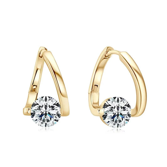 “Sterling silver hug hoop earrings with 6.5mm round moissanite, shown in gold tone on wood background”