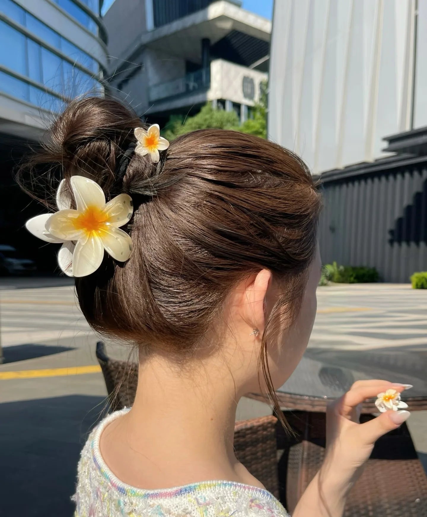 Woman with styled hair featuring flowers outdoors