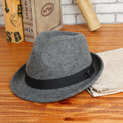 Gray fedora hat with a black band on a wooden surface