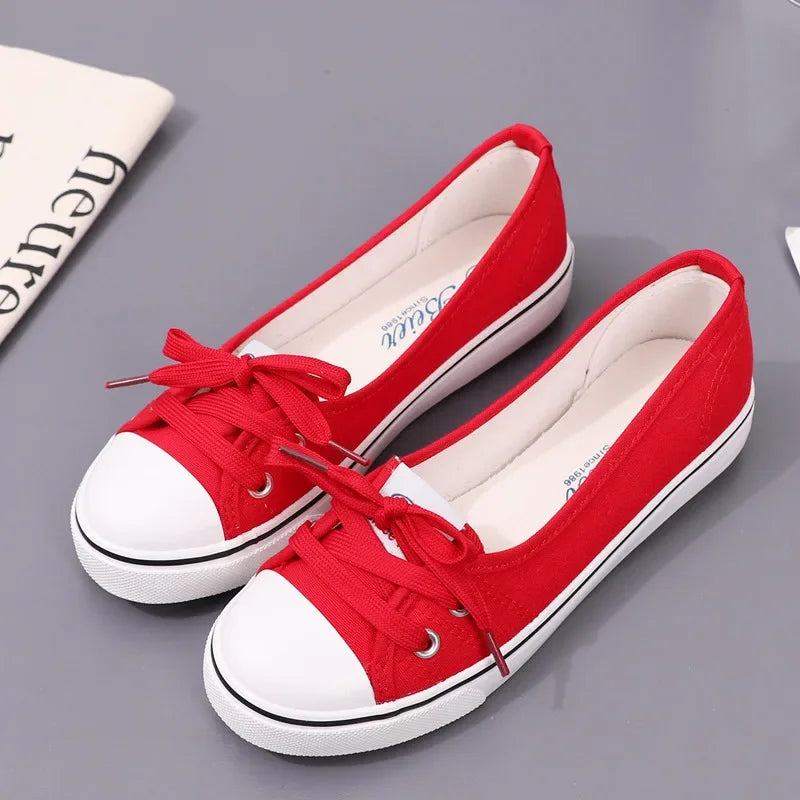 Red sneakers with white soles on a gray surface