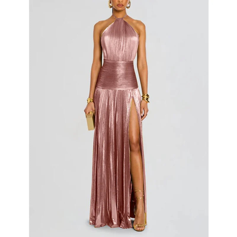 Woman wearing a metallic pink halter neck gown with a slit on a light gray background