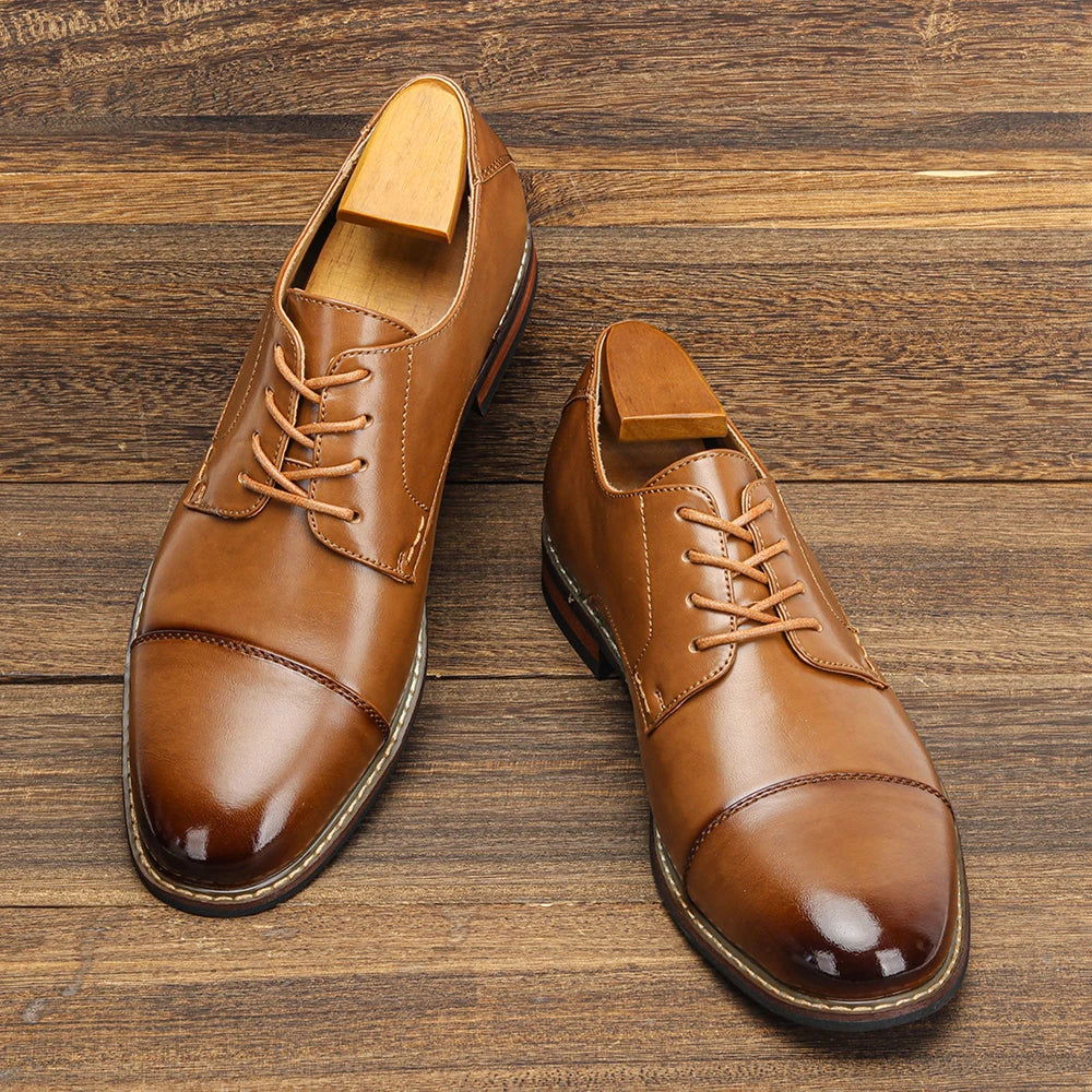Pair of brown leather dress shoes on a wooden surface