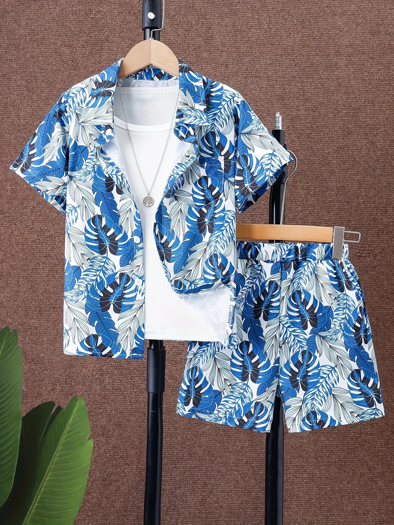 Blue and white floral shirt and shorts set on hangers against a brown background