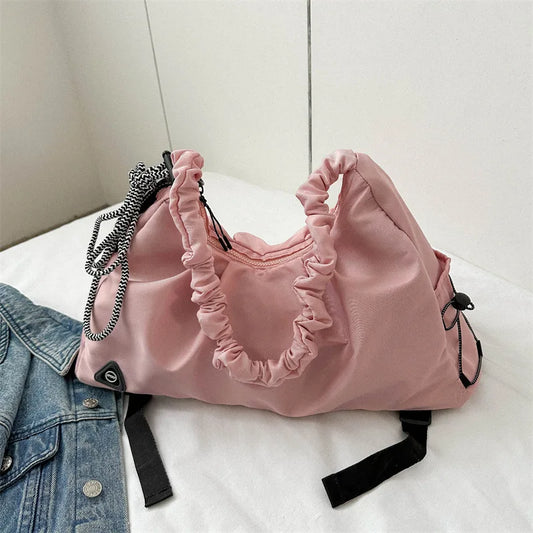 Pink drawstring bag with ruffled details on a white surface