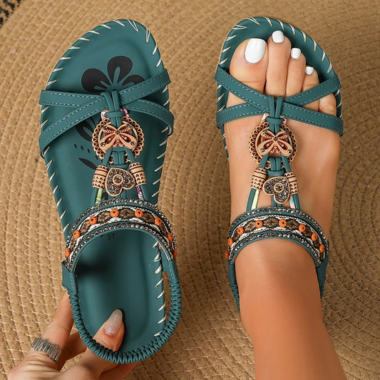 Teal sandals with decorative elements on a textured surface