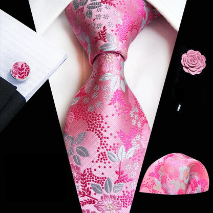 Pink floral tie set with matching pocket square and cufflinks on a black and white background