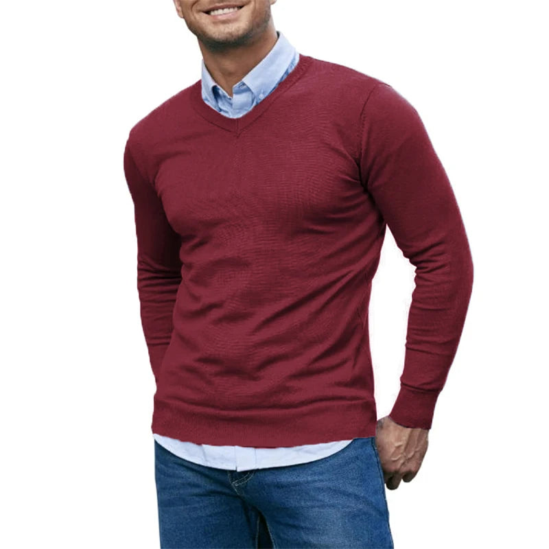 Man wearing a red sweater over a light blue shirt on a white background