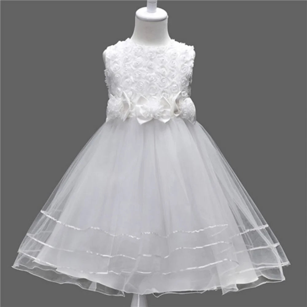 White flower girl dress on a mannequin against a dark gray background