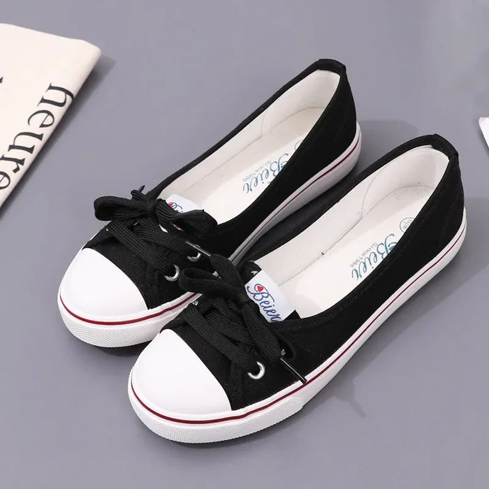 Black and white sneakers on a gray surface with a newspaper in the background