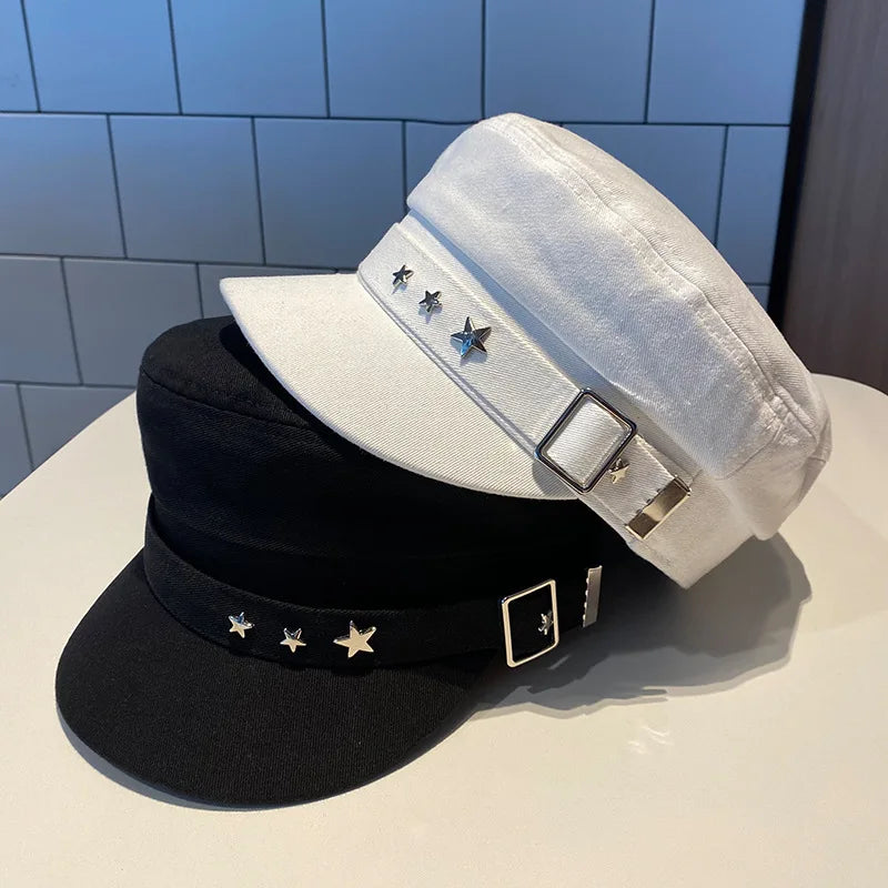 Black and white caps with star and buckle details on a light surface.