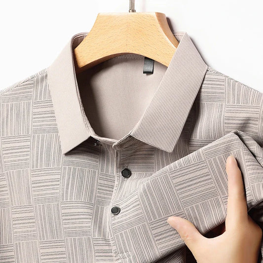 Plaid polo shirt on a hanger with a hand touching the fabric