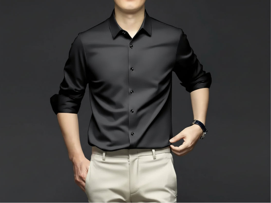 Man wearing a black shirt with text and branding on a dark background
