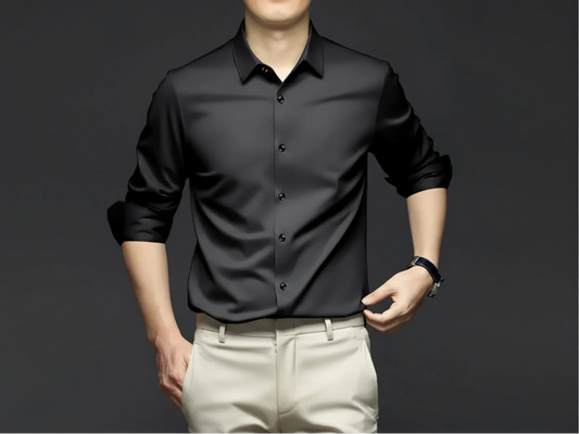 Man wearing a black shirt with text and branding on a dark background