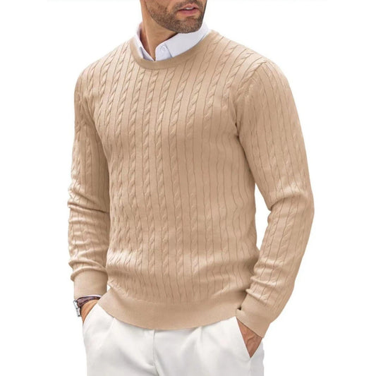 Man wearing a beige cable knit sweater and white pants on a white background
