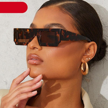 Woman wearing tortoiseshell sunglasses with a neutral background