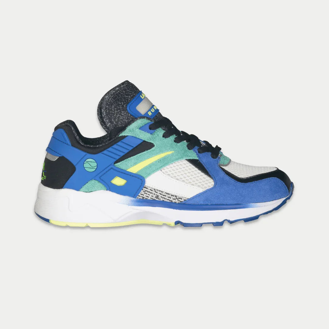 Multicolored sneaker with blue, green, and black design on a light gray background