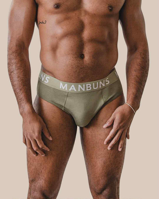 Man wearing olive green underwear with 'MANBUNS' branding on a beige background
