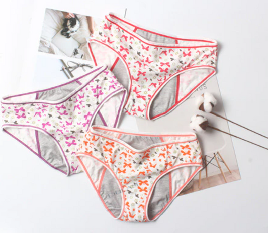 Three pairs of women's underwear with floral patterns on a light surface.